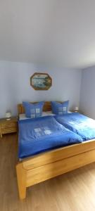 una camera da letto con letto con lenzuola blu e cuscini blu di Ferienhälfte Insel Rügen a Glowe
