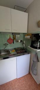 una cucina con mobili bianchi e un lavandino di Ferienhälfte Insel Rügen a Glowe