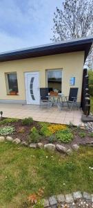 a house with a patio with two chairs and a table at Ferienhälfte Insel Rügen in Glowe