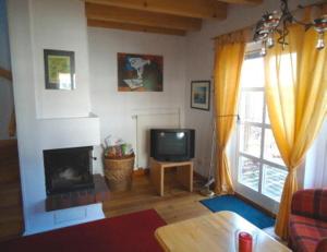 a living room with a fireplace and a television at Ferienhaushälfte Fleesensee in Göhren-Lebbin