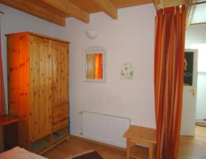 a living room with white walls and a wooden cabinet at Ferienhaushälfte Fleesensee in Göhren-Lebbin