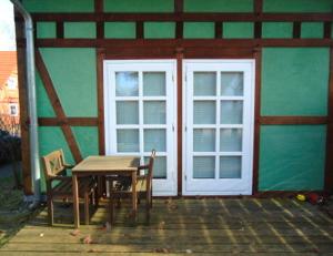 a table and chairs in front of a building with a door at Ferienhaushälfte Fleesensee in Göhren-Lebbin