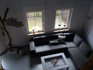 een woonkamer met een bank en twee ramen bij Ferienhaus am Fleesensee in Silz +3 foto's