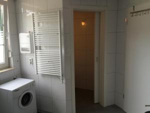 een wasruimte met een wasmachine en een raam bij Ferienhaus am Fleesensee in Silz