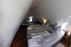 two beds in a attic room with two lamps at Ferienhaus in Waren Müritz in Waren
