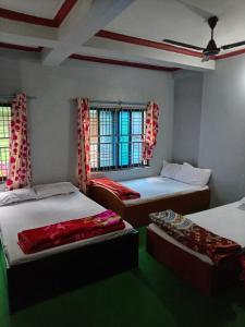 a room with three beds and two windows at Baglung Durbang Guest House in Pokhara