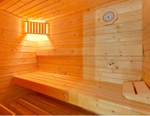 een houten sauna met een klok aan de muur bij Ferienhaus Krakower See in Serrahn +9 foto's