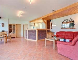 een woonkamer met een rode bank en een tafel bij Ferienhaus Krakower See in Serrahn