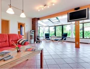 een woonkamer met een rode bank en een tv bij Ferienhaus Krakower See in Serrahn