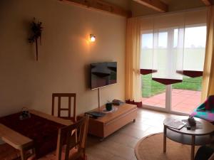 a living room with a tv and a table and a dining room at Ferienhaus zwischen den Seen in Funfseen