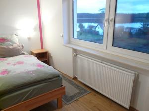 a bedroom with a bed and two windows at Ferienwohnung mit Seeblick in Lychen