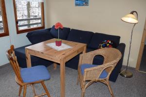 un soggiorno con divano blu, tavolo e sedie di Ferienhaus beim Stechlinsee a Neuglobsow