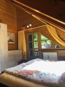 een slaapkamer met een bed en een groot raam bij Blockhaus am Waldrand in Brieselang