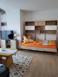 een slaapkamer met een groot bed met oranje lakens bij Ferienwohnung Zühlensee in Wesenberg