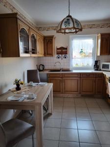 een keuken met houten kasten en een tafel en een raam bij Ferienwohnung Zühlensee in Wesenberg