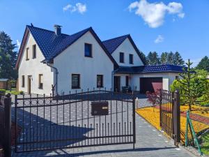 a white house with a black fence in front of it at Ferienwohnung Zühlensee in Wesenberg