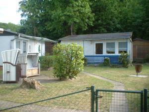 a house with a fence in front of a yard at Ferienbungalow Fleesensee in Malchow