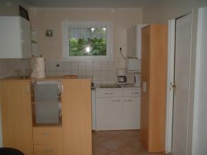 a kitchen with white cabinets and a window at Ferienbungalow Fleesensee in Malchow