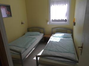 two beds in a small room with a window at Ferienbungalow Fleesensee in Malchow