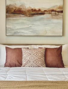 un dipinto appeso sopra un letto con cuscini di Chic Units at Ivory Residences a Davao
