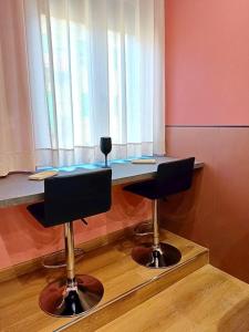 a table with two chairs in a room with a window at Marilù Accoglienza del Sud in Foggia