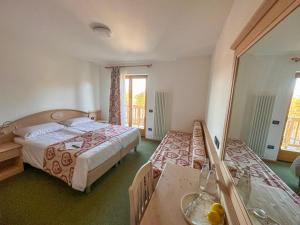 une chambre d'hôtel avec deux lits et une table dans l'établissement Hotel Alpe Bellaria, à Candriai