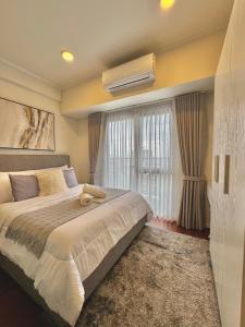 una camera da letto con un letto grande e una finestra di Chic Units at Ivory Residences a Davao