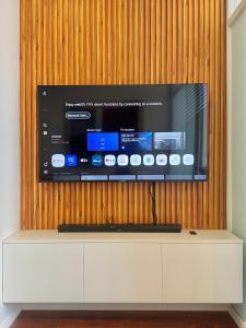 una TV a schermo piatto su una parete di legno di Chic Units at Ivory Residences a Davao
