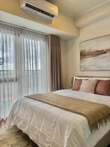 una camera da letto con un letto grande e una finestra di Chic Units at Ivory Residences a Davao Altre 46 foto
