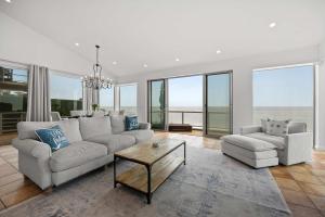 un soggiorno con un divano, un tavolo e delle sedie di New Listing Beachfront Retreat by Colby & Conrad a Solromar