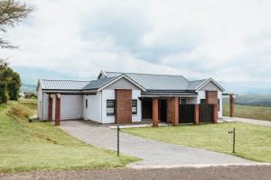 ein Haus auf einem Hügel mit Auffahrt in der Unterkunft Disa Close 3 Cathkin Estates in Winterton