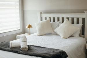 a white bed with white pillows and a towel on it at Disa Close 3 Cathkin Estates in Winterton
