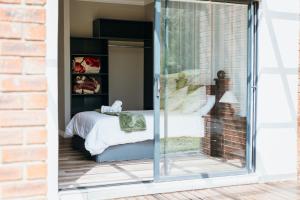 a bedroom with a bed through a sliding glass door at Disa Close 3 Cathkin Estates in Winterton