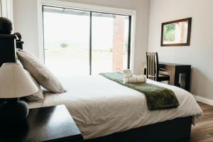 ein Schlafzimmer mit Bett, Schreibtisch und Fenster in der Unterkunft Disa Close 3 Cathkin Estates in Winterton