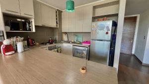 a kitchen with a stainless steel refrigerator in it at Departamento Costa Pucón in El Cerrillo +3 photos