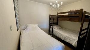 a bedroom with two bunk beds and a chandelier at Departamento Costa Pucón in El Cerrillo
