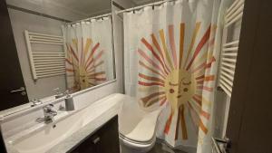 a bathroom with a sink and a toilet and a shower curtain at Departamento Costa Pucón in El Cerrillo