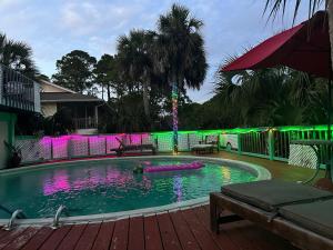 una grande piscina con illuminazione verde e viola di Fun Beach House With Pool Alligator Point a Sun N Sand Beaches