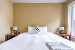 a bedroom with a large white bed with two tables at Jungle House Luxury Stays - Columbus Downtown Short North in Columbus +50 photos