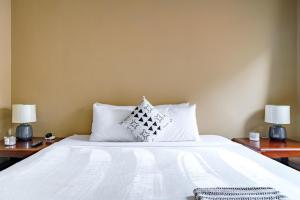 a bed with white sheets and pillows on it at Jungle House Luxury Stays - Columbus Downtown Short North in Columbus