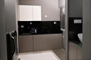 una cocina con armarios en blanco y negro y fregadero en Transit Suites by GrandWest, en Nedumbassery 39 fotos más