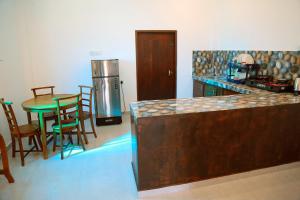 a kitchen with a table and chairs and a refrigerator at Urban Tide Dickwella in Batigama