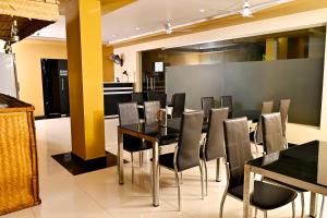 Un comedor con una mesa y sillas negras. en Transit Suites by GrandWest, en Nedumbassery