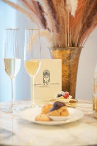 a table with a plate of food and two glasses of wine at Duse Luxury Stay in Milan