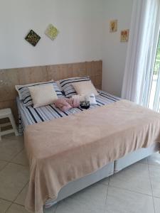 een bed met een deken erop in een slaapkamer bij Garcida in Governador Celso Ramos