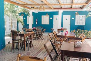 a restaurant with wooden tables and chairs and blue walls at Pousada Recanto Porto de Galinhas in Porto De Galinhas