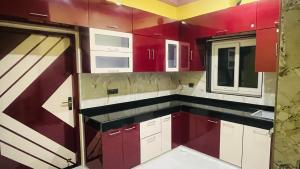 a kitchen with red and white cabinets and a window at Shree LaadliJu Kothi in Deoghar