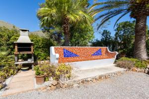 un banc avec des flèches bleues dessus à côté d'un palmier dans l'établissement Villa Sea and Mountain Nadal Jardi, à Alcúdia