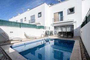 ein Swimmingpool vor einem weißen Gebäude in der Unterkunft Villa Conchas by Algarvemanta in Manta Rota