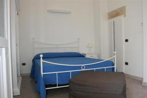 een slaapkamer met een blauw bed en een blauwe deken bij Corte Lecciso in Leverano